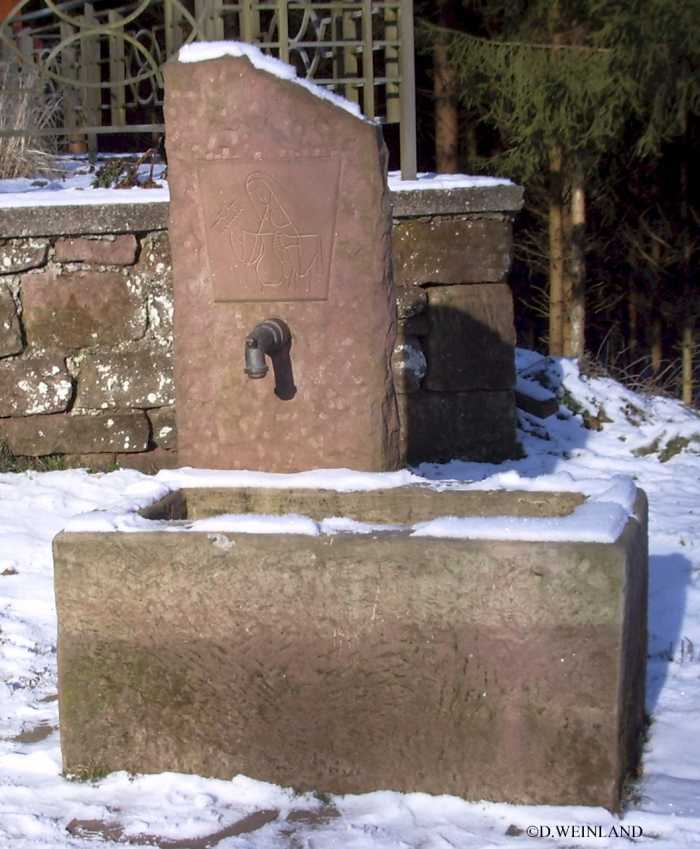 Fontaine récente en grès, avec une effigie moderne de Sainte Vérène